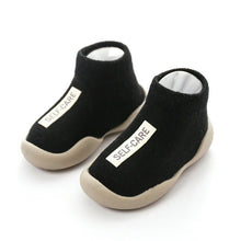 Black slip-on shoes with 'SELF-CARE' label on a white background