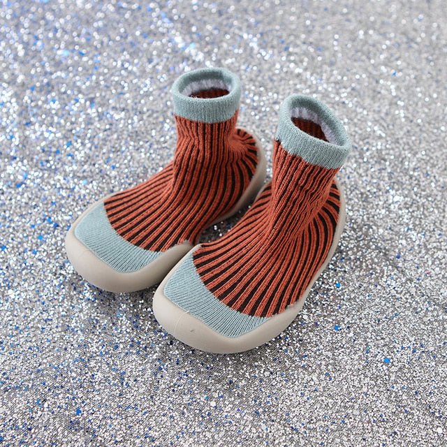 Pair of orange knit baby boots with light blue trim