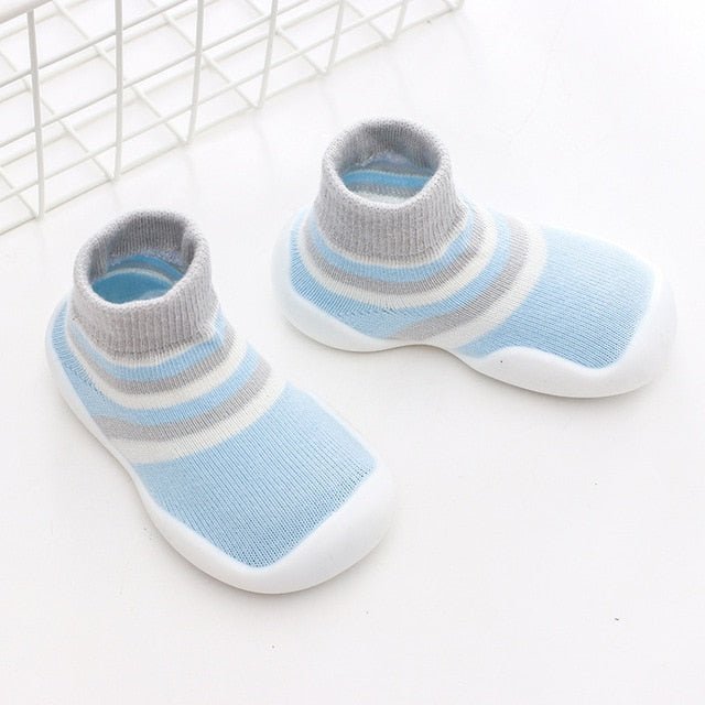 Pair of baby shoes with blue and gray stripes on a white background