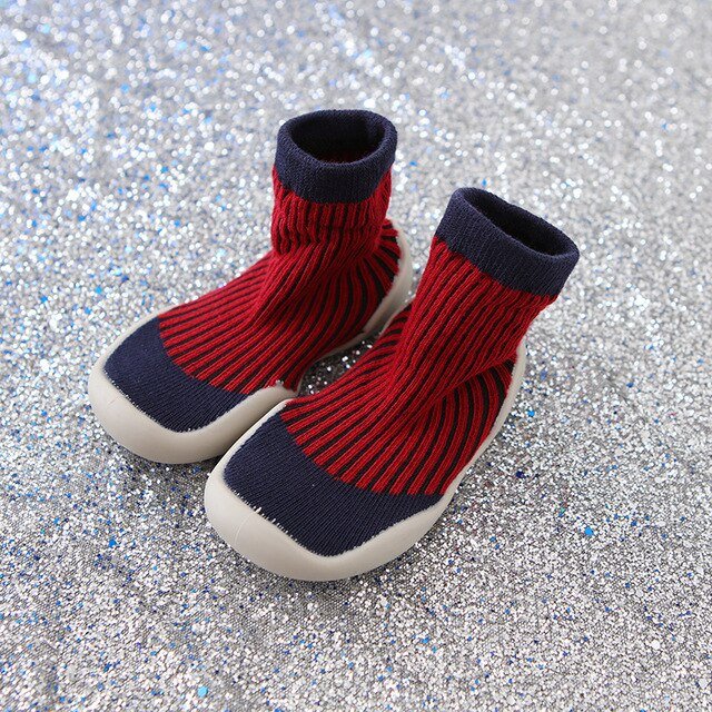 Red and navy baby boots on a glittery silver background