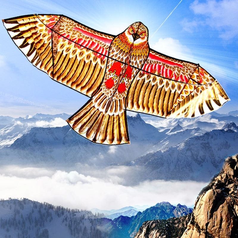 Decorative kite shaped like a bird flying over mountainous landscape