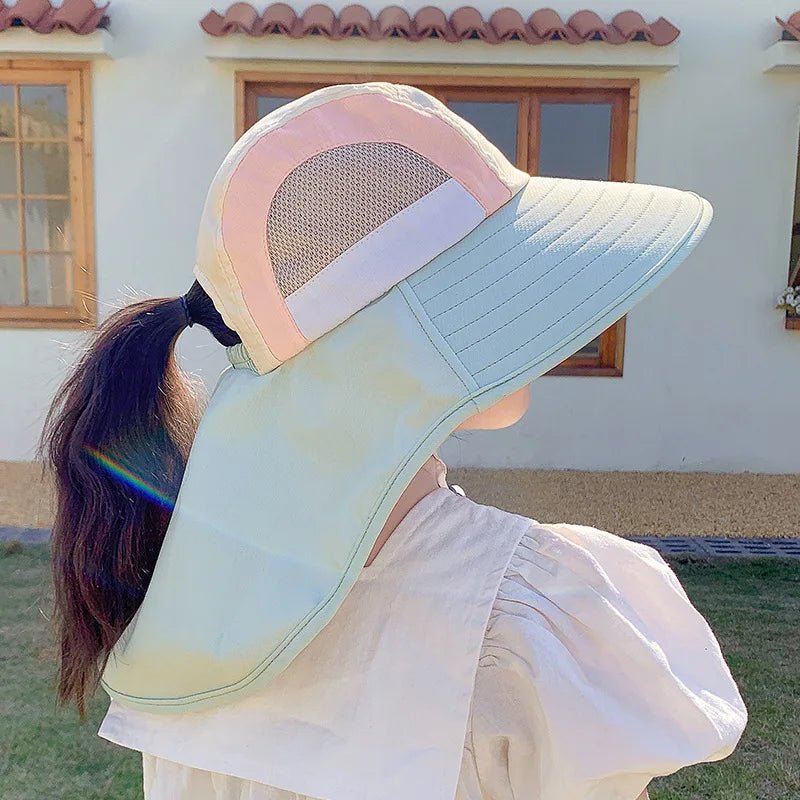 Person wearing a colorful visor hat outdoors with a building in the background