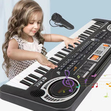 Child playing the kids piano keyboard with microphone on a light blue background for early music practice.