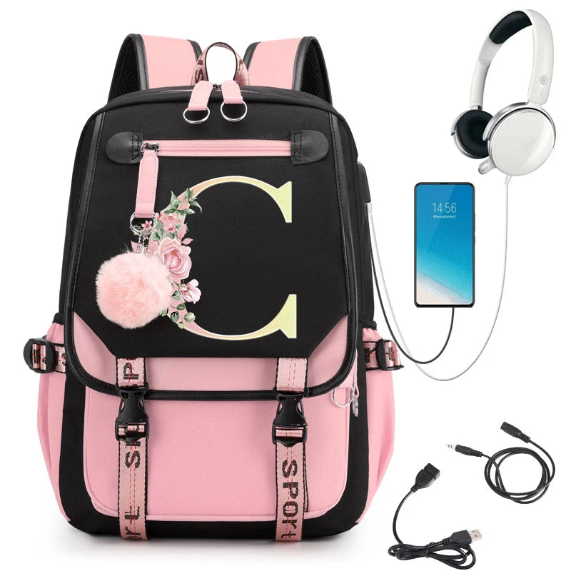 Pink and black backpack with floral design, phone, headphones, and USB cable.