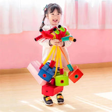 Child holding colorful toy blocks in a classroom setting