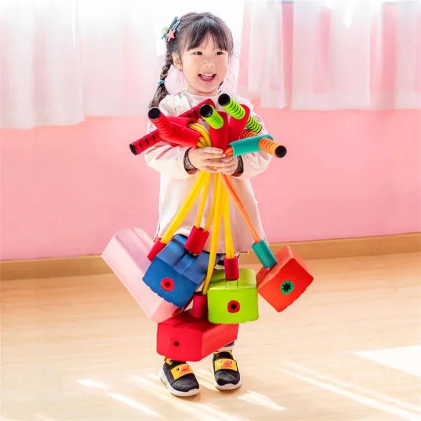 Child holding colorful toy blocks in a classroom setting