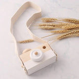 Wooden toy camera with a strap and wheat.