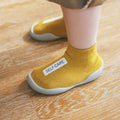 Yellow socks with 'SELF-CARE' label worn by a person 