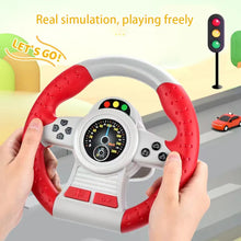 Hands holding a red and grey toy steering wheel with a traffic light and toy car in the background