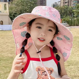 Child wearing a pink sun hat with leaf patterns outdoors