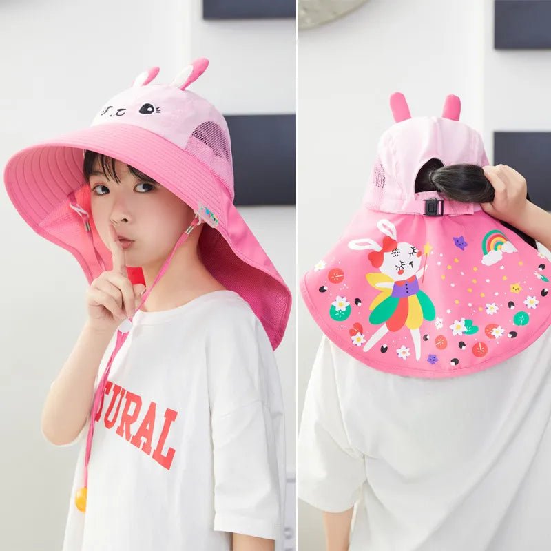 Child wearing a pink sun hat with a detachable face shield, held by another person.