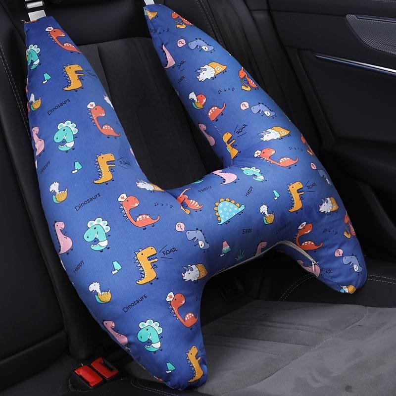 Blue U-shaped car pillow with dinosaur pattern on a car seat