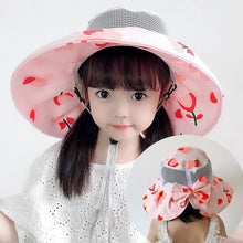 Child wearing a pink floral sun hat with a cherry design