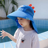 Child wearing a blue sun hat with a dinosaur design by a pool.