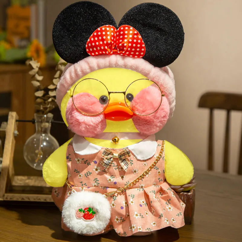 Cafe duck plush toy dressed with mouse ears on a wooden surface for playful costume collecting.