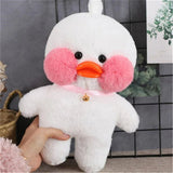 White plush duck toy with pink cheeks and orange beak held by a hand against a gray tiled wall.