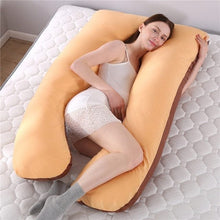 Large U shaped maternity body pillow with full length support for whole body comfort during pregnancy sleep.