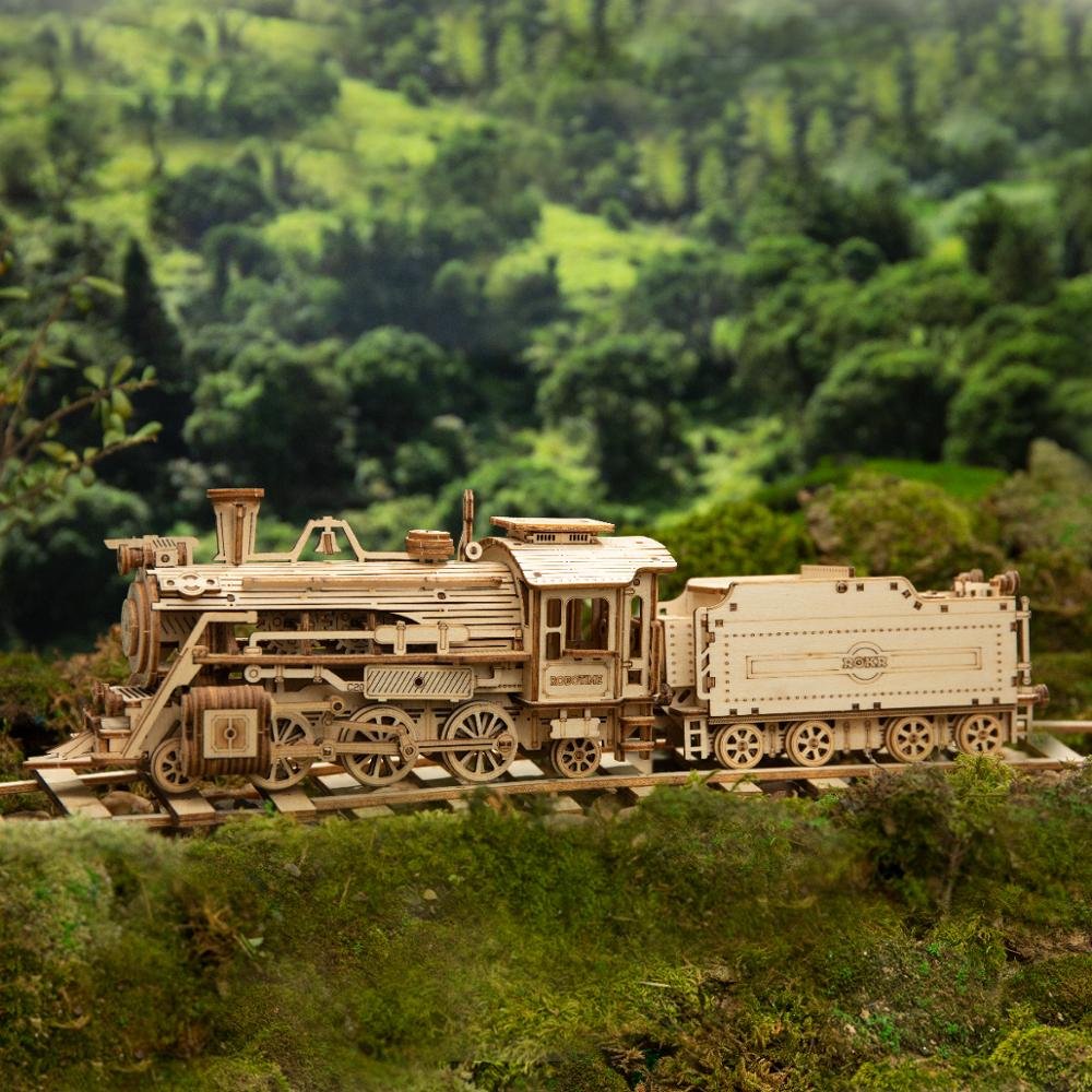 Wooden model train on tracks with a forest background