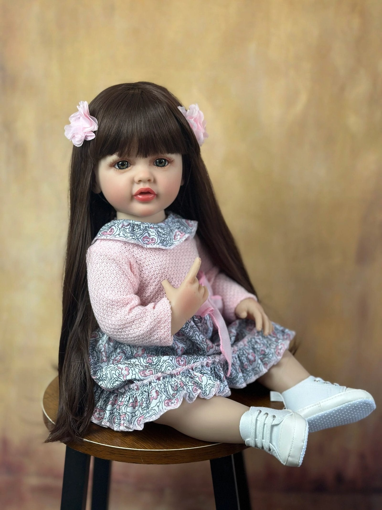 Lifelike soft silicone Reborn Baby Girl with long hair in a pink dress and white shoes for dress-up play and gifting.