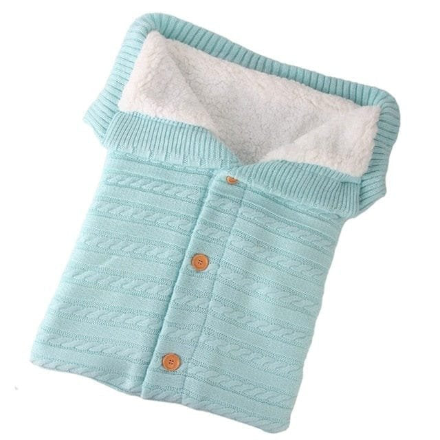 Light blue baby sleeping bag in a travel friendly knit for car seats, prams, and overnight trips.