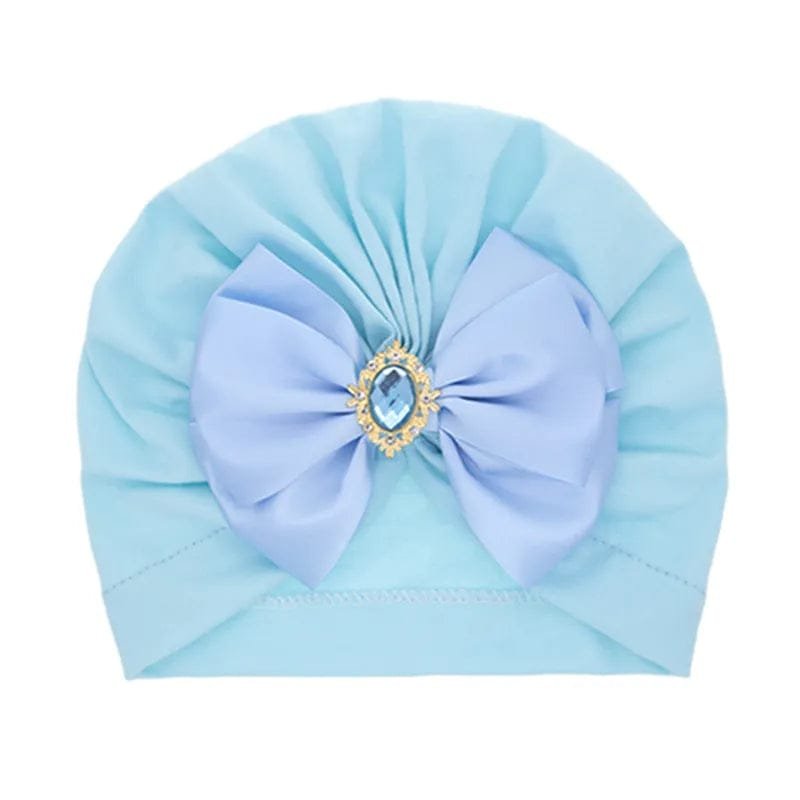 Light blue baby turban with purple bow and rhinestone centre for parties, gifting, and cute daily dressing.