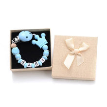 Light blue silicone beaded pacifier clip personalized with baby name packaged in a gift box for baby showers.