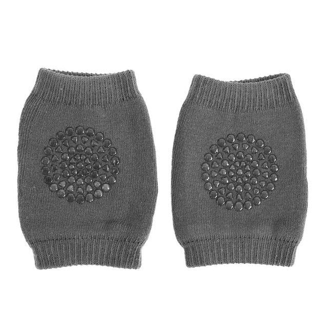 Pair of gray knit arm warmers with circular patterns.