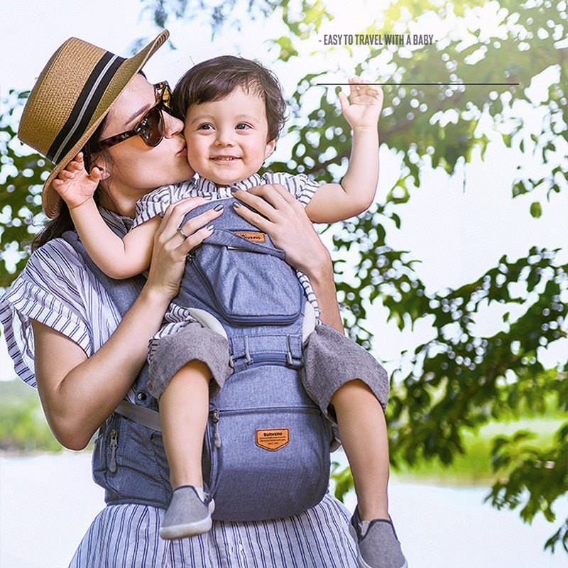 A woman holding a child in a baby carrier