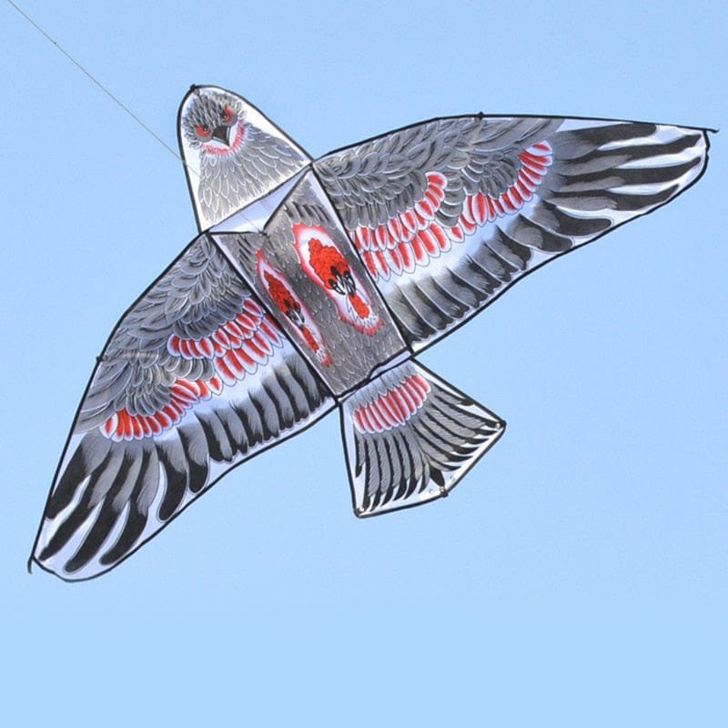Decorative kite with black, red, and gray design against a clear blue sky
