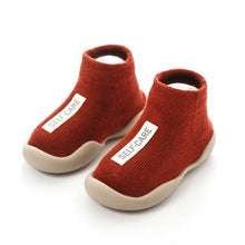 Red baby shoes with 'SELF-CARE' label 