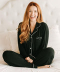 A woman wearing black pajamas with a visible brand logo.