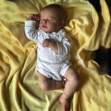 LouLou Reborn Doll 50cm realistic silicone head and cloth body baby doll resting on a yellow blanket for collectors and gifting.