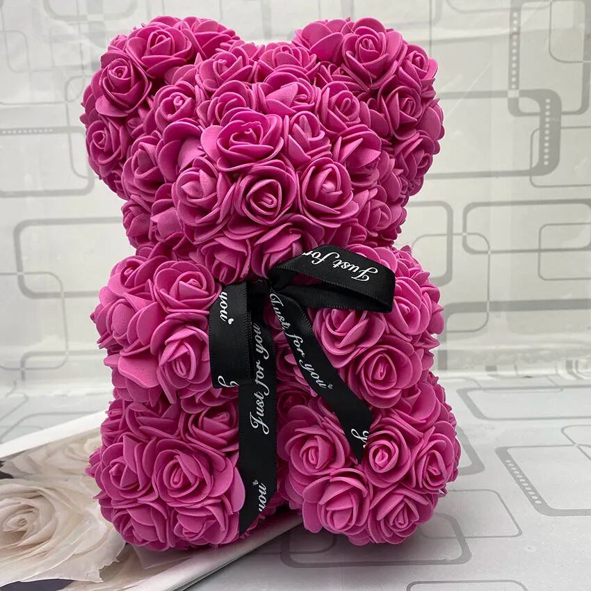 Pink rose-shaped flower with black ribbon.