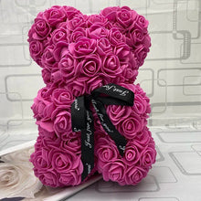 Pink rose-shaped flower with black ribbon.