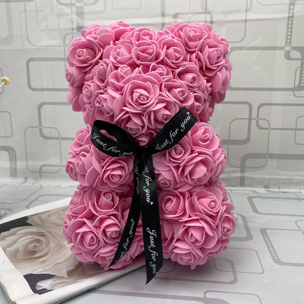 Pink rose teddy bear with a black ribbon