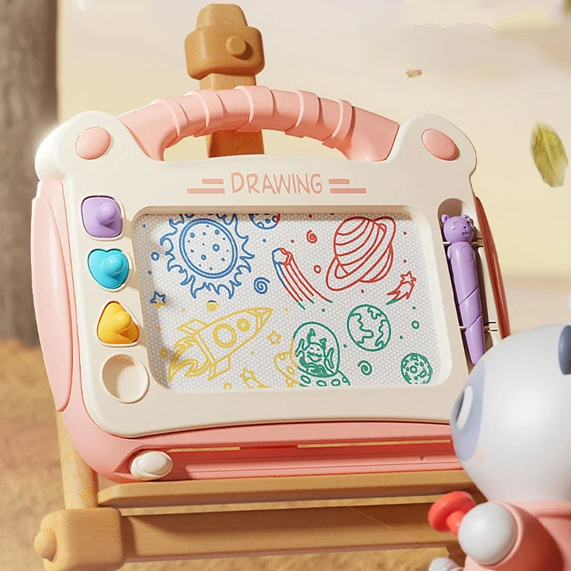 Pink magnetic drawing board on an easel with space and rocket doodles