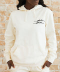 Person wearing a white hoodie with 'ma ma' text.