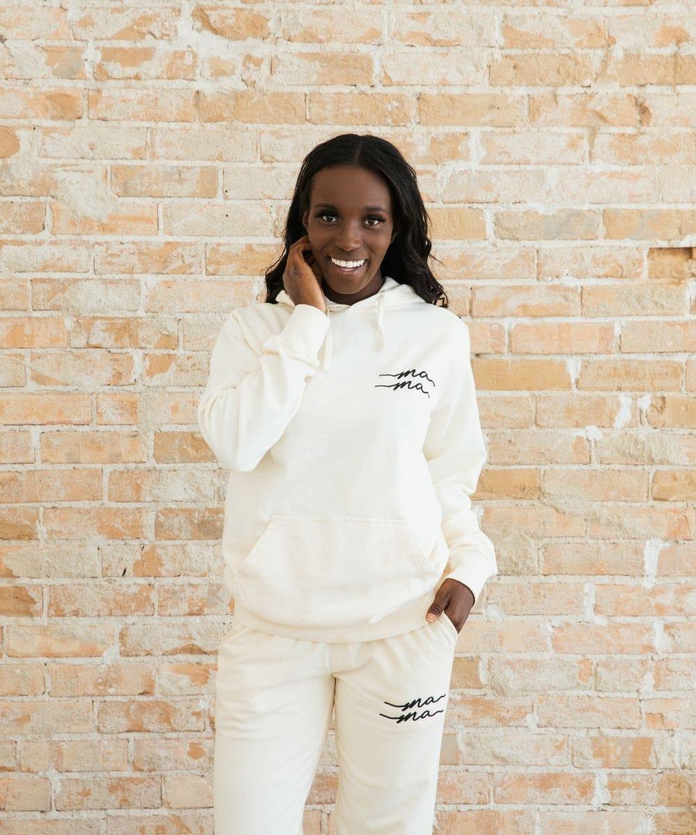 Person wearing a white hoodie and pants with text.