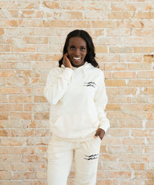 Person wearing a white hoodie and pants with text.