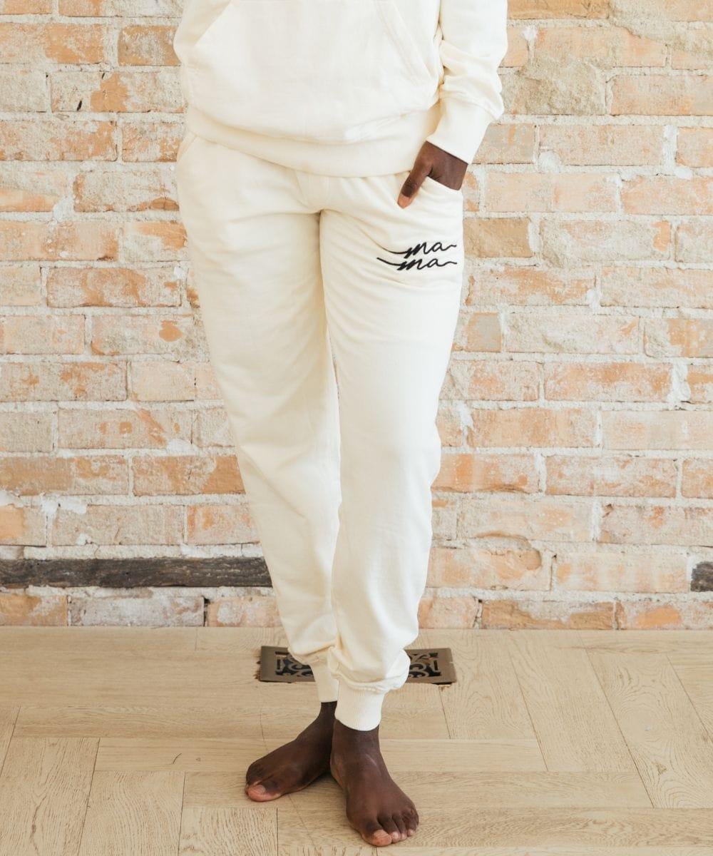 Person wearing white sweatpants with text.