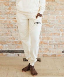 Person wearing white sweatpants with text.