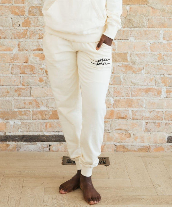Person wearing white sweatpants with text.