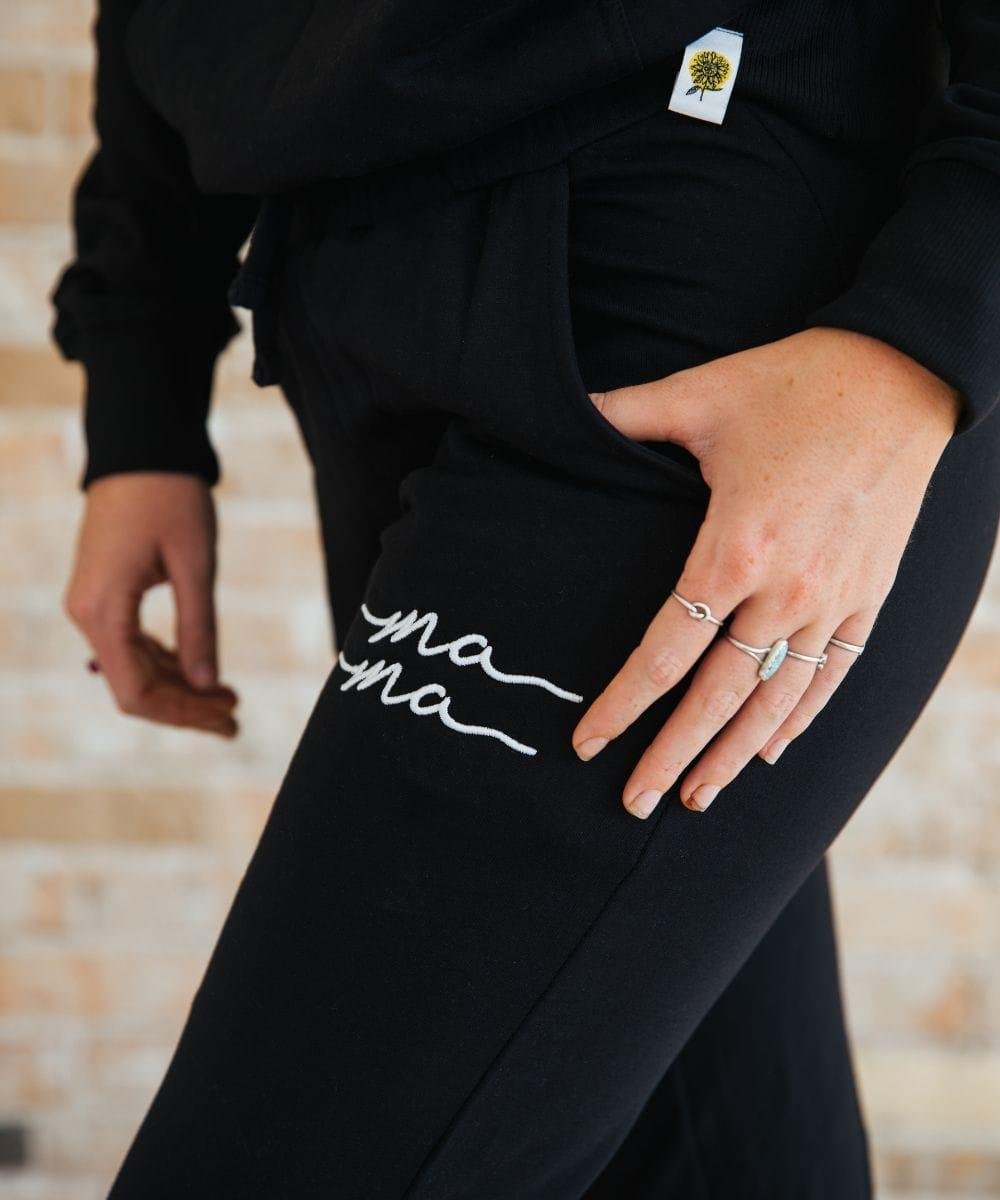 Black pants with 'mama' embroidery.