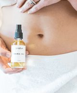 Person holding a bottle of 'Mama Oil'.