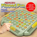 Hand flipping a playing piece on the green Memory Flipped Fun board with yellow storage slots