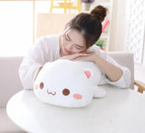 Woman sitting on a couch with a large, cute plush toy resembling a cat.