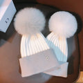 Pair of natural mink pom pom knit beanies for kids winter warmth, school runs, and cold weather outings.