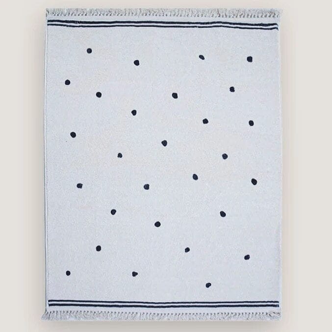 White towel with black polka dots on a light gray background