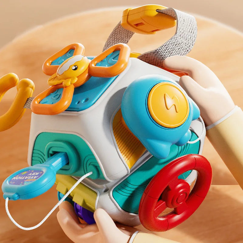 Busy cube with a steering wheel, spinner and wristband strap held in two hands, second view