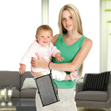 Mum carrying a baby and the portable diaper changing bag for one-handed nappy changes during everyday outings.